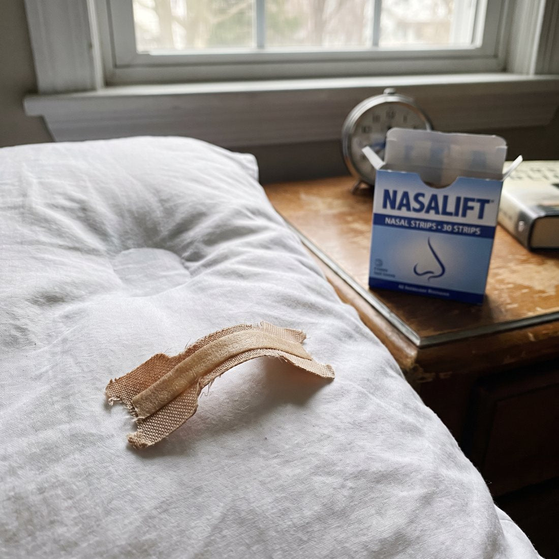 Used nasal strip on a pillow in morning light